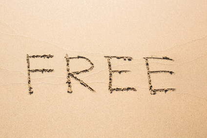 Free word handwritten in sand on sunny summer beach